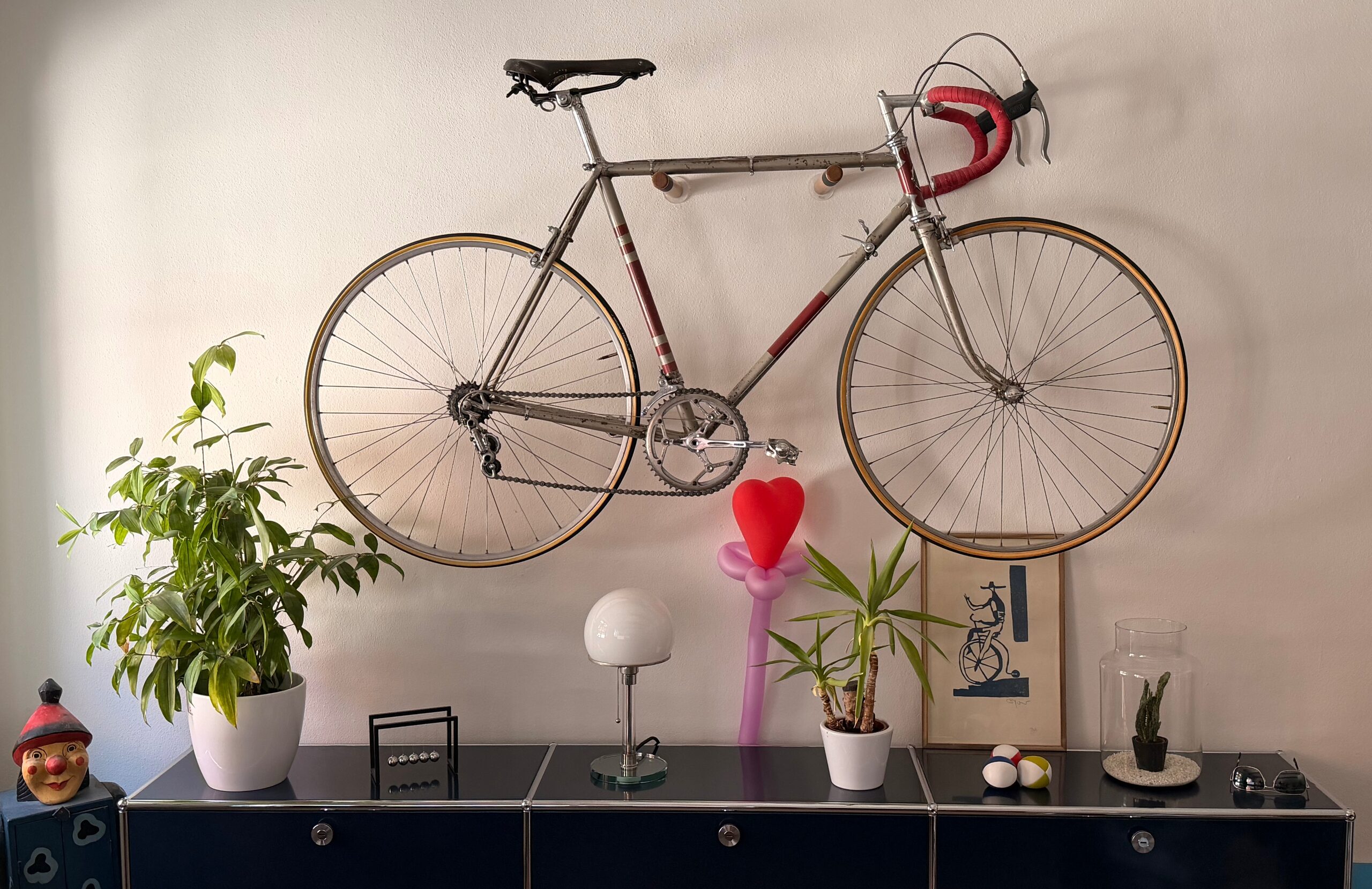 Road bike mounted on the wall above a sideboard